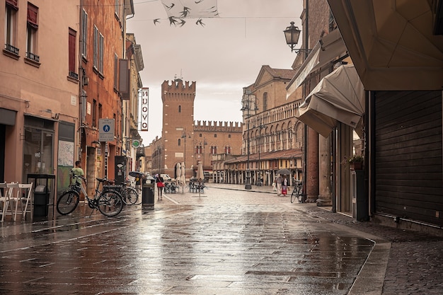 FERRARA, ITALIA 29 LUGLIO 2020 : Vista suggestiva della strada che conduce a Piazza Trento Trieste a Ferrara in Italia con le persone nella loro vita quotidiana