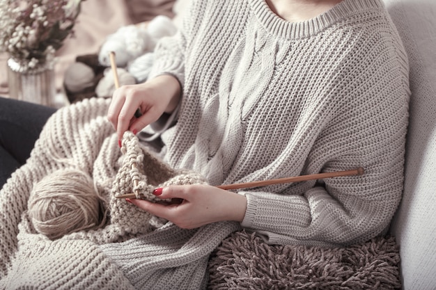 Ferri da maglia e filati di legno d'annata in mani della donna