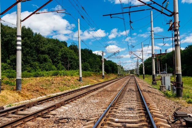 Ferrovia panoramica nella zona rurale e cielo blu con nuvole bianche in estate