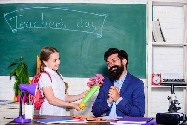 Festa degli insegnanti Daugghter e padre con fiori piccola scolaretta ragazzina con bouquet di fiori la giornata della conoscenza è il 1 settembre ritorno a scuola Felice festa degli insegnanti regalo di fiori per il miglior insegnante