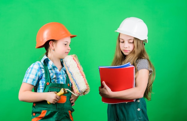 Festa del lavoro 1 maggio Ispettore caposquadra Progetto scuola di riparazione piccole ragazze che riparano insieme in officina Bambini piccoli in casco con tablet e rullo Concetto di festa del lavoro Festa del lavoro per i bambini