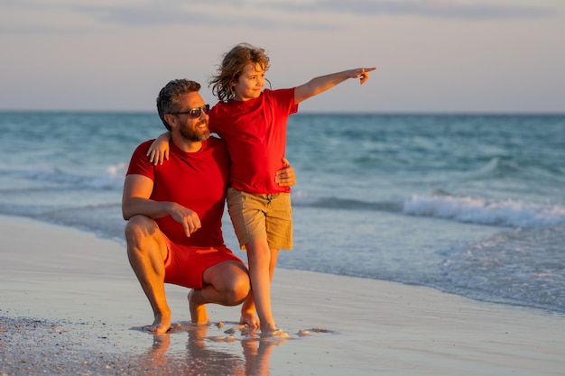 Festa del papà padre che cammina con un figlio piccolo sulla spiaggia vicino al mare papà con figlio che cammina su una summe