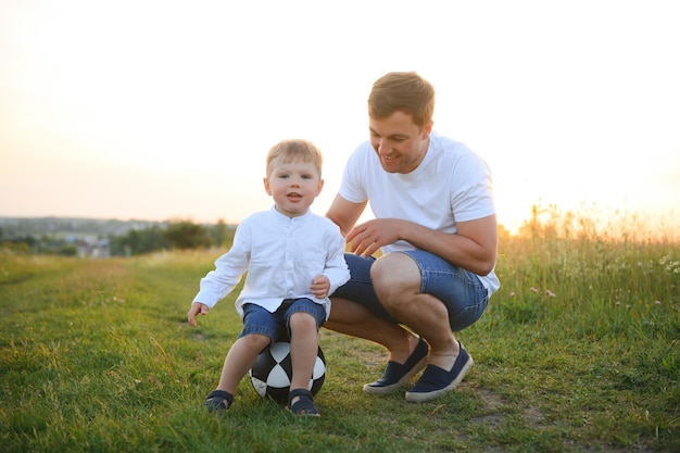 Festa del papà Padre di famiglia felice e figlio del bambino che giocano e ridono sulla natura al tramonto