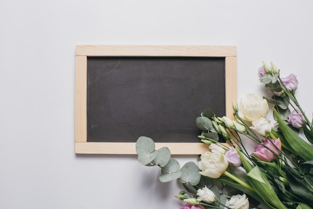 Festa della mamma Composizione: Eustoma, eucalipto e una lavagna su uno sfondo bianco.