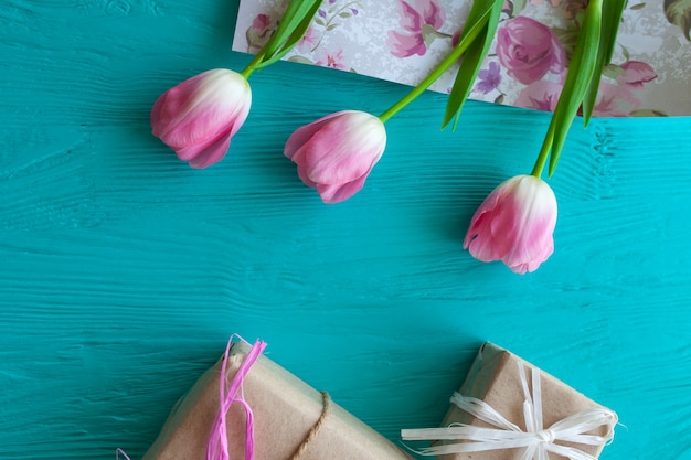 Festa della mamma. Tulipani rosa e regali su sfondo blu