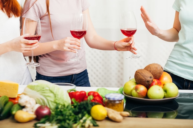 Festa delle donne. Stile di vita sano senza alcol. Ragazza che rifiuta il bicchiere di vino rosso.