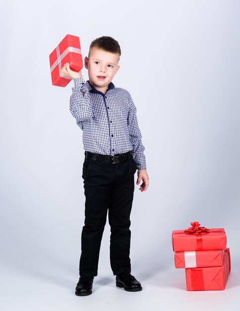 Festa di compleanno bambino felice con scatola regalo Ragazzino di Natale con regalo di San Valentino Shopping Giorno di Santo Stefano Assistente di negozio di Capodanno Infanzia felice Bambino positivo che si diverte a fare shopping