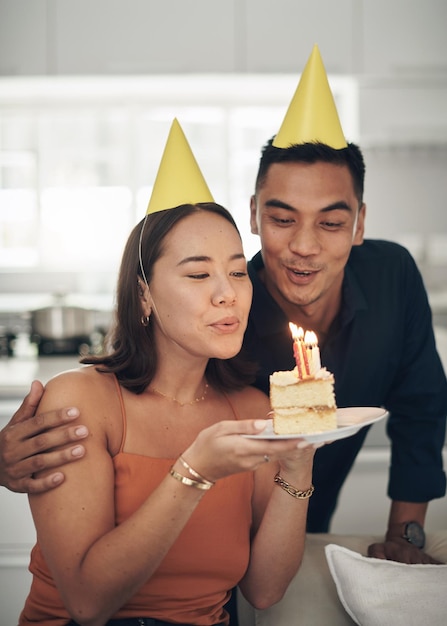 Festa di compleanno e coppia con le candele sulla torta che si godono la celebrazione del giorno speciale e dell'anniversario insieme Amore incontri e uomo e donna soffiano la fiamma sul dolce dolcetto e celebrano la felicità