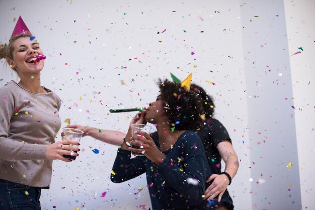 festa di coriandoli felice gruppo di giovani che festeggia il capodanno mentre balla e si diverte a casa