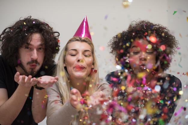 festa di coriandoli felice gruppo di giovani che festeggia il capodanno mentre balla e si diverte a casa