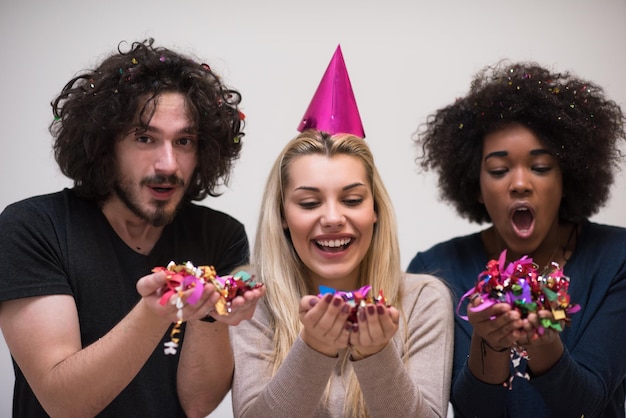 festa di coriandoli Gruppo di giovani felici multietnici che festeggiano il capodanno mentre ballano e si divertono a casa