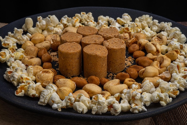 Festa di giugno Arachidi popcorn caramelle arachidi e pacoca su fondo di legno rustico