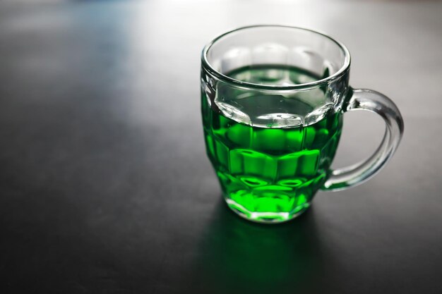 Festa di San Patrizio. Festa nazionale irlandese. Birra verde. Mano con un boccale di birra color smeraldo in un bar.