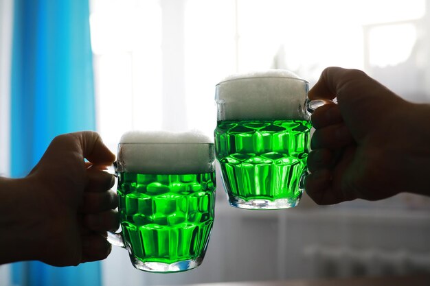 Festa di San Patrizio. Festa nazionale irlandese. Birra verde. Mano con un boccale di birra color smeraldo in un bar.