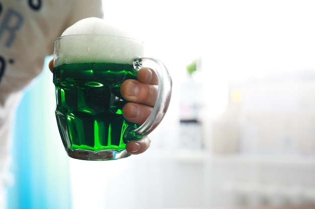 Festa di San Patrizio Festa nazionale irlandese Birra verde Mano con un boccale di birra color smeraldo in un bar