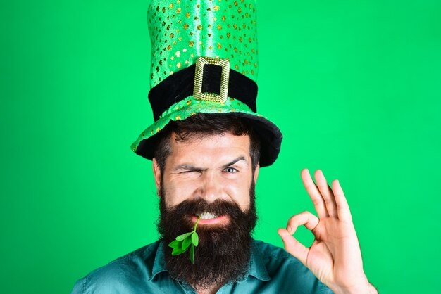 Festa di San Patrizio. L'uomo barbuto in cappelli da uomo verde celebra il giorno di Patrick. Festa di San Patrizio. Cappello da uomo verde o cappelli a cilindro. Cappello verde con trifoglio. San Patrizio si diverte. Irlanda tradizionale.