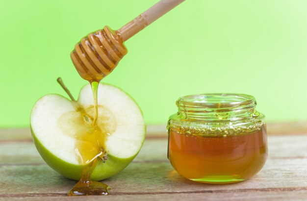 Festa ebraica di mele Rosh Hashanah miele in barattolo e goccia di miele sulle mele verdi