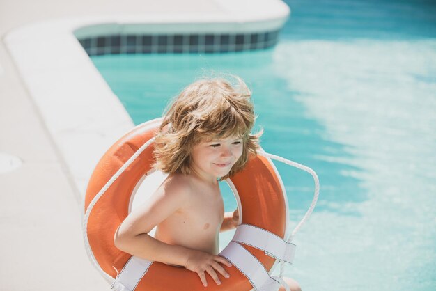 Festa in piscina. Ragazzo in piscina. Bambino con cerchio di gomma. Attività estive. Week-end estivo per bambini.