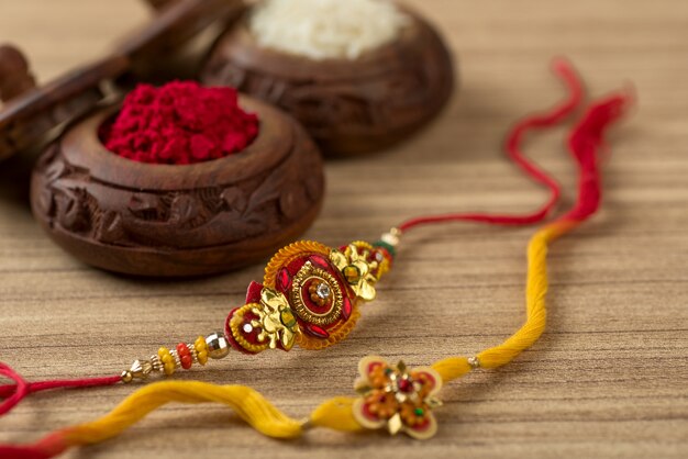 Festa indiana: sottofondo Raksha Bandhan con un elegante Rakhi, Chicchi di Riso e Kumkum