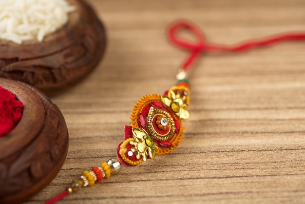 Festa indiana: sottofondo Raksha Bandhan con un elegante Rakhi, Chicchi di Riso e Kumkum