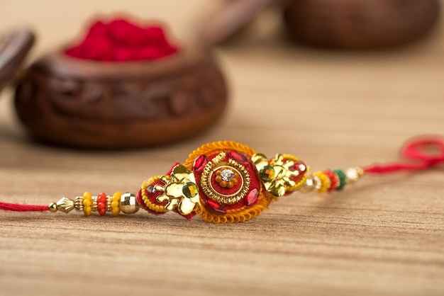 Festa indiana: sottofondo Raksha Bandhan con un elegante Rakhi, Chicchi di Riso e Kumkum