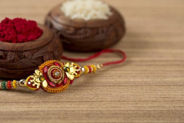 Festa indiana: sottofondo Raksha Bandhan con un elegante Rakhi, Chicchi di Riso e Kumkum