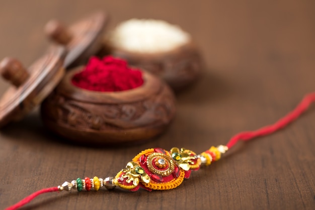 Festa indiana: sottofondo Raksha Bandhan con un elegante Rakhi, Chicchi di Riso e Kumkum