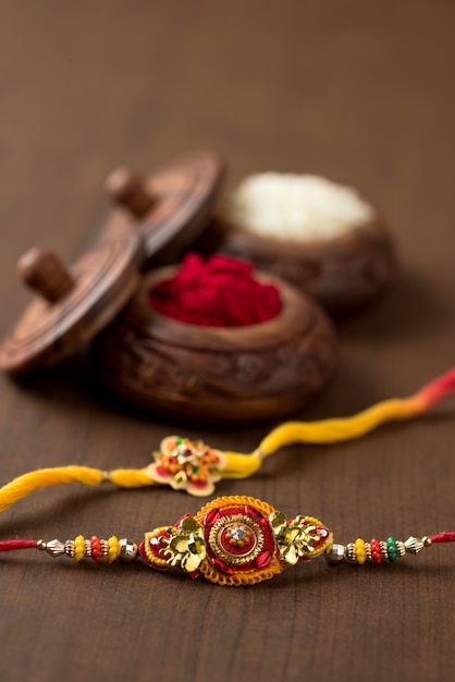 Festa indiana: sottofondo Raksha Bandhan con un elegante Rakhi, Chicchi di Riso e Kumkum