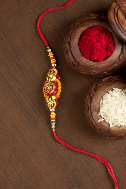 Festa indiana: sottofondo Raksha Bandhan con un elegante Rakhi, Chicchi di Riso e Kumkum