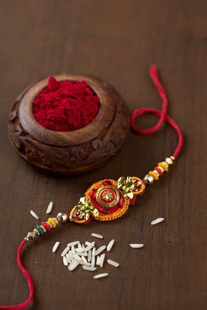 Festa indiana: sottofondo Raksha Bandhan con un elegante Rakhi, Chicchi di Riso e Kumkum