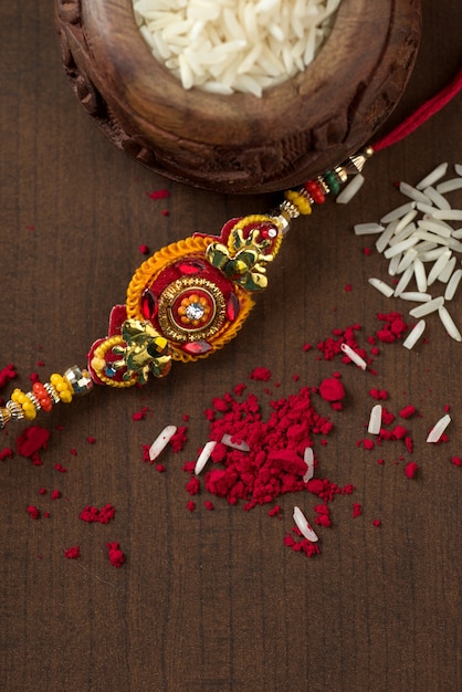 Festa indiana: sottofondo Raksha Bandhan con un elegante Rakhi, Chicchi di Riso e Kumkum