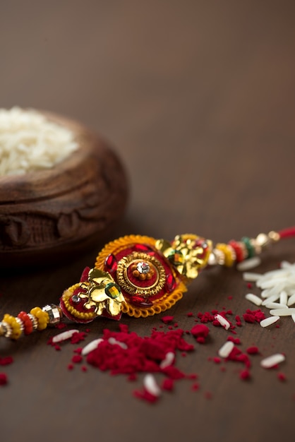 Festa indiana: sottofondo Raksha Bandhan con un elegante Rakhi, Chicchi di Riso e Kumkum