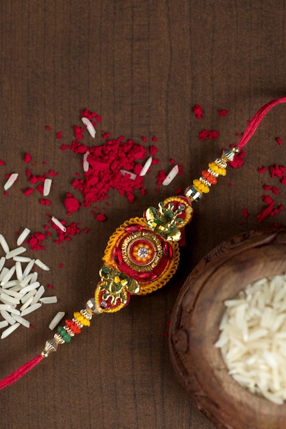 Festa indiana: sottofondo Raksha Bandhan con un elegante Rakhi, Chicchi di Riso e Kumkum