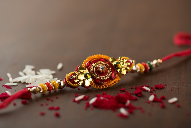 Festa indiana: sottofondo Raksha Bandhan con un elegante Rakhi, Chicchi di Riso e Kumkum