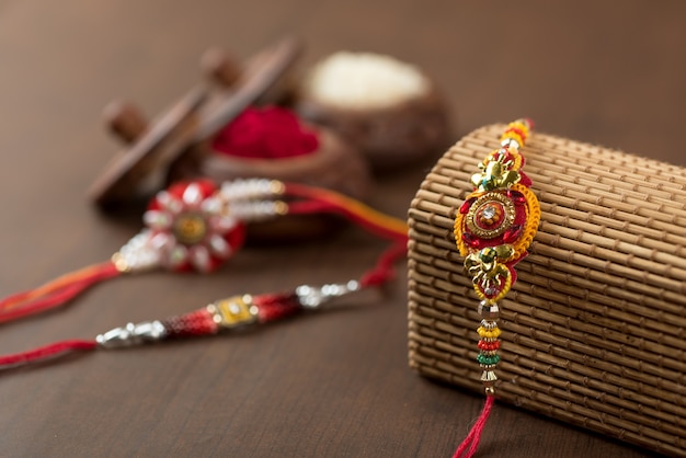 Festa indiana: sottofondo Raksha Bandhan con un elegante Rakhi, Chicchi di Riso e Kumkum