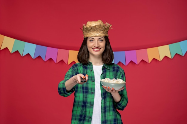 Festa junina con cappello di paglia ragazza carina che celebra il festival brasiliano mangiando mais