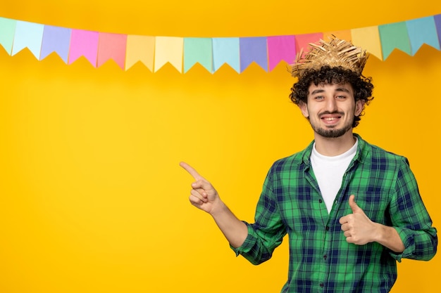 Festa junina giovane ragazzo carino con cappello di paglia e bandiere colorate festival brasiliano con un buon segno