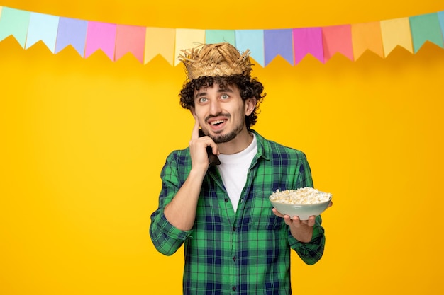Festa junina giovane ragazzo carino con cappello di paglia e bandiere colorate festival brasiliano sulla telefonata