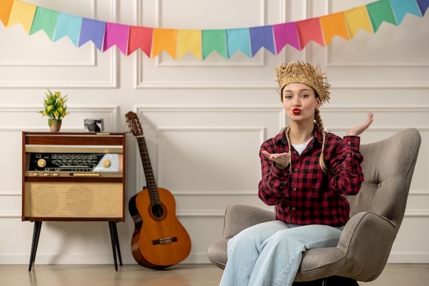 Festa junina ragazza carina con cappello di paglia brasiliano di mezza estate con chitarra radiofonica retrò che invia baci