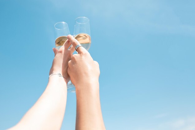 Festa stagionale al resort sulla spiaggia. Chiudere le mani degli amici che celebrano, riposano, si divertono, tintinnano