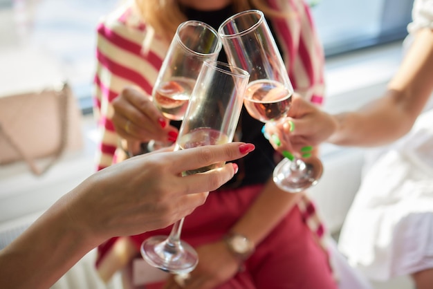 Festeggiando con bicchieri di alcol in mano amiche felici che si divertono