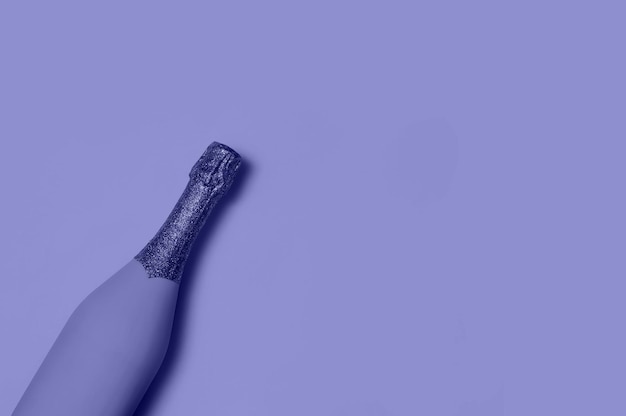 Festiva bottiglia di champagne minimalista su sfondo blu concetto creativo molto peri colore del