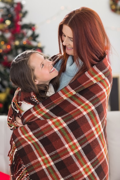 Festiva madre e figlia avvolta in coperta