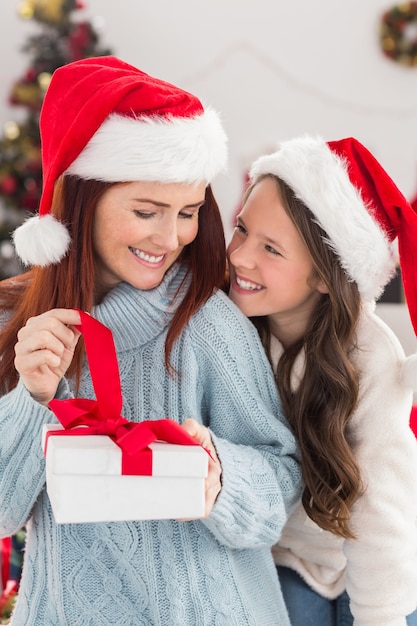 Festiva madre e figlia sul divano con regalo