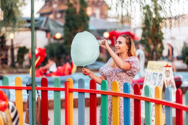 Festival estivo Donna bella e sognante che mangia un cotone dolce al parco divertimenti Il concetto di vacanza vacanza e felicità