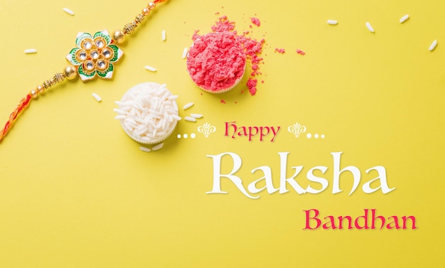 Festival indiano Raksha Bandhan con bellissimi chicchi di riso e Rakhi su sfondo giallo Un tradizionale cinturino da polso indiano che è un simbolo dell'amore tra sorelle e fratelli