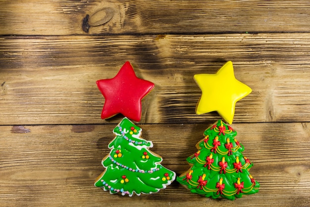 Festivi biscotti di panpepato natalizio a forma di albero di Natale e stelle. Pan di zenzero saporiti sulla tavola di legno. Vista dall'alto