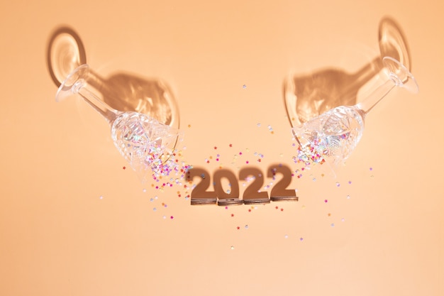 Festivo capodanno piatto con numeri 2022 e ombre dure con occhiali e decorazioni lucide