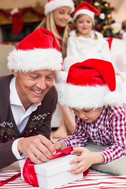 Festivo padre e figlio che aprono il regalo di Natale