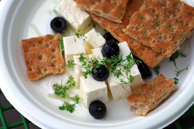 Feta con olive microgreens e cracker Spuntino o spuntino sano Formaggio bianco con olio d'oliva